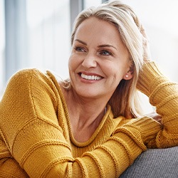 Woman smiling while relaxing on couch