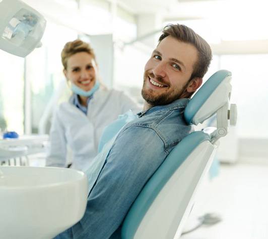 Happy dental patient looking over his shoulder