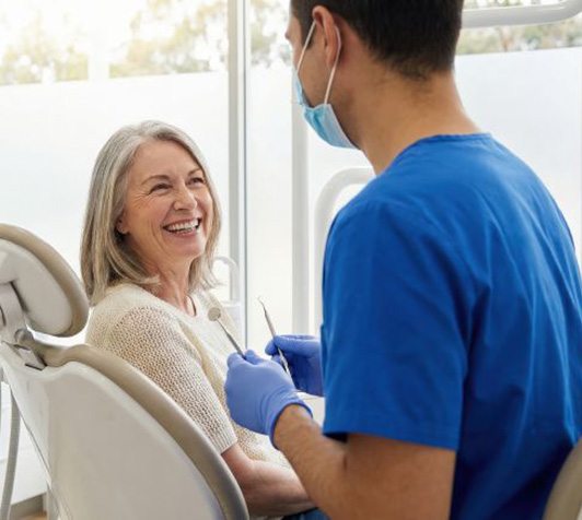 Happy senior patient interacting with her dentist