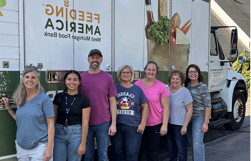 Multiple people standing outside a truck carrying food