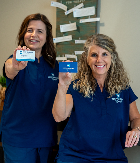 Dental team members holding up business cards