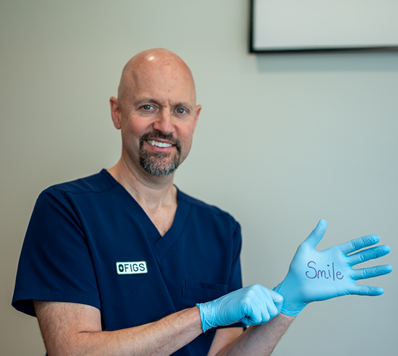 Dr. Mularczyk pulling on gloves