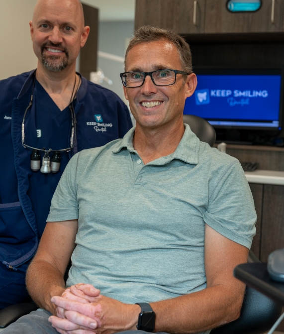Dental team member holding dentures and brushing them